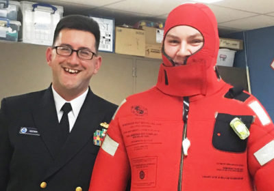 Officer next to person in red cold water survival suit