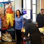 There are two images. One is of two women standing on each side of a NOAA Teacher at Sea sign. The other is a man in a military uniform talking with people.
