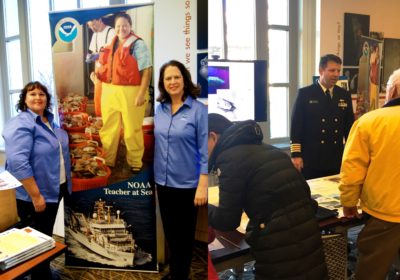 There are two images. One is of two women standing on each side of a NOAA Teacher at Sea sign. The other is a man in a military uniform talking with people.