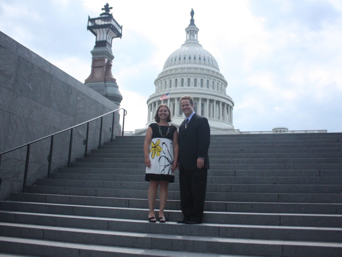 A man and a woman stand on the steps of the US Capitol.
