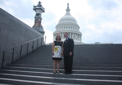 A man and a woman stand on the steps of the US Capitol.