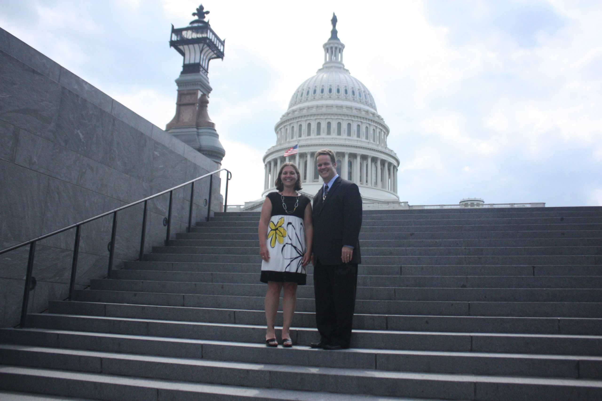 A man and a woman stand on the steps of the US Capitol.