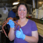 A woman holds a long legged crab