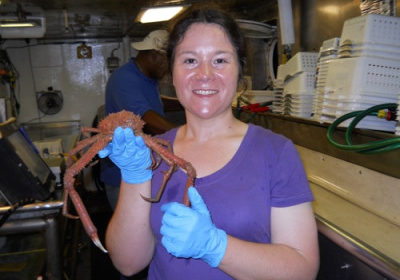 A woman holds a long legged crab