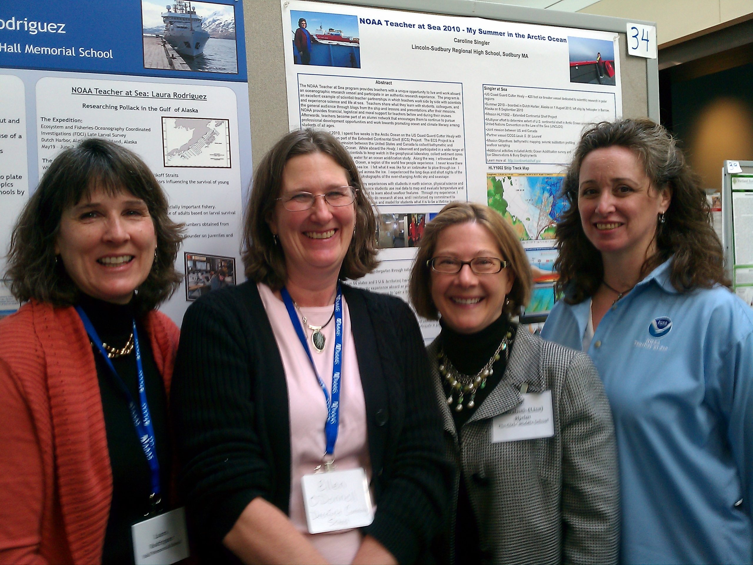 Four women stand in front of a NOAA Teacher at Sea sign.
