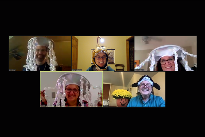 A group of people in a Zoom meeting and they are all wearing different marine animal hats.