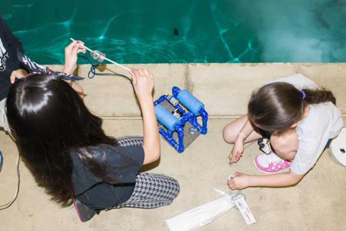 Students launching mini ROV by a pool