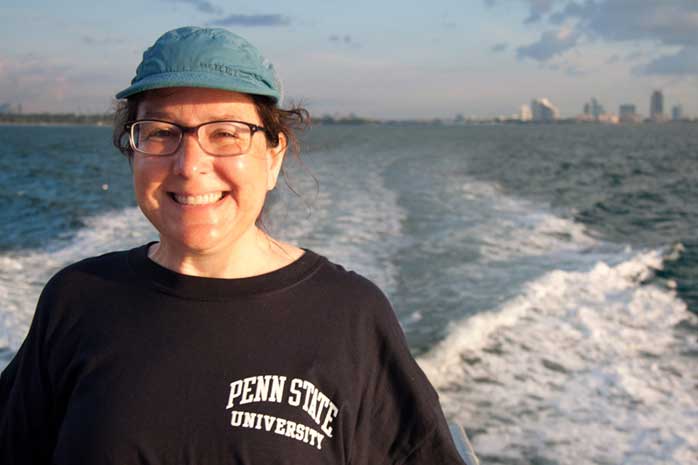 Person with Penn State University tshirt onboard ship with boat wake behind her