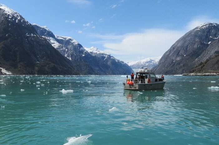NOAA vessel in Alaskan waters amids snow covered peaks