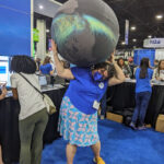 NOAA Outreach Coordinator lifting large globe model