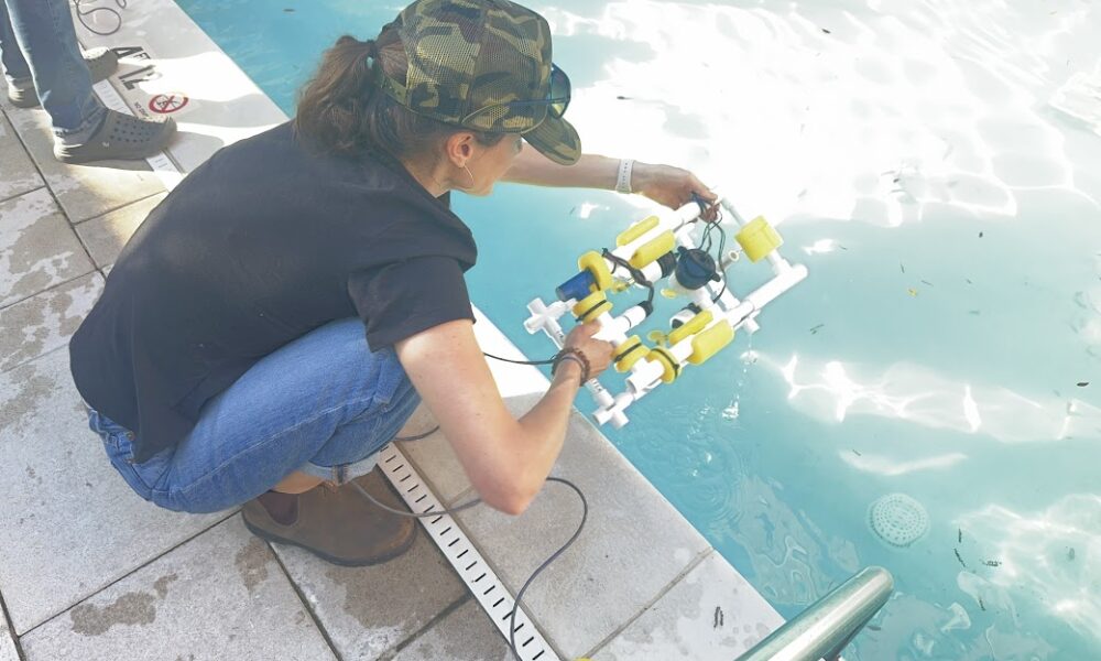 Woman placing mini ROVe in a swimming pool