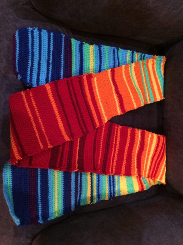 Knitted scarf with rows in shades of orange and blue