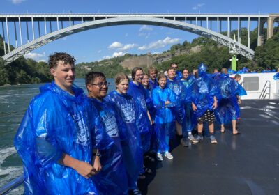 Students in blue raincoats under a bridge at Niagara Falls