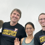 Four people wearing black t-shirts that read Ambitious Axolotls