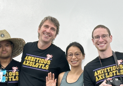 Four people wearing black t-shirts that read Ambitious Axolotls