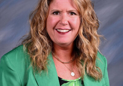 profile picture of blond woman wearing a green blazer and blouse